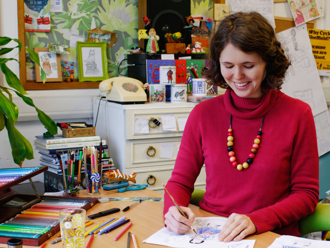 Photograph of children's illustrator and trail designer Emma Metcalfe drawing by hand in Nottingham